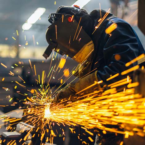 Metal worker using a grinder man welding
